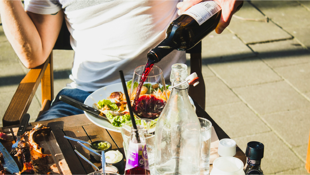 bediening schenkt een glas wijn in op een horeca terras