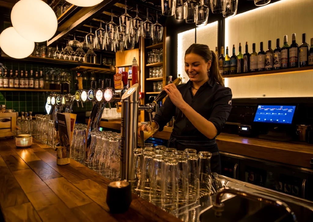 bediening werkt achter de bar met een untill barscherm