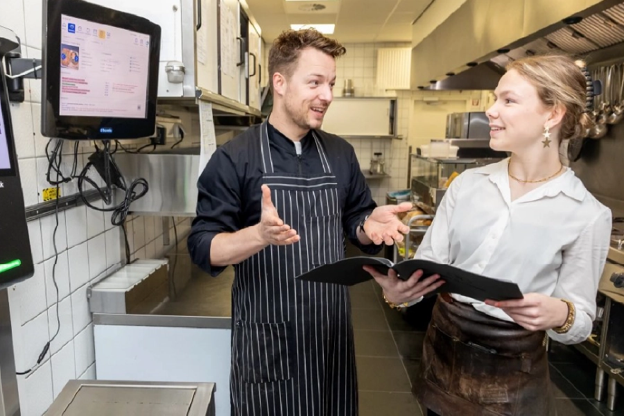 chef en bediening in gesprek bij horeko kitchen manager