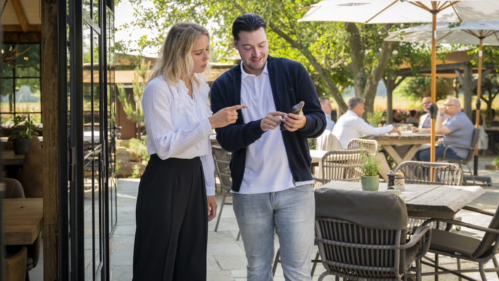 Horeca-adviseur die de handheld uitlegt