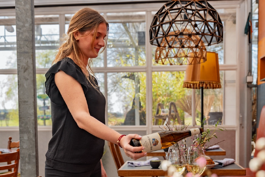 horeca bediening schenkt wijn in bij brass boer thuis