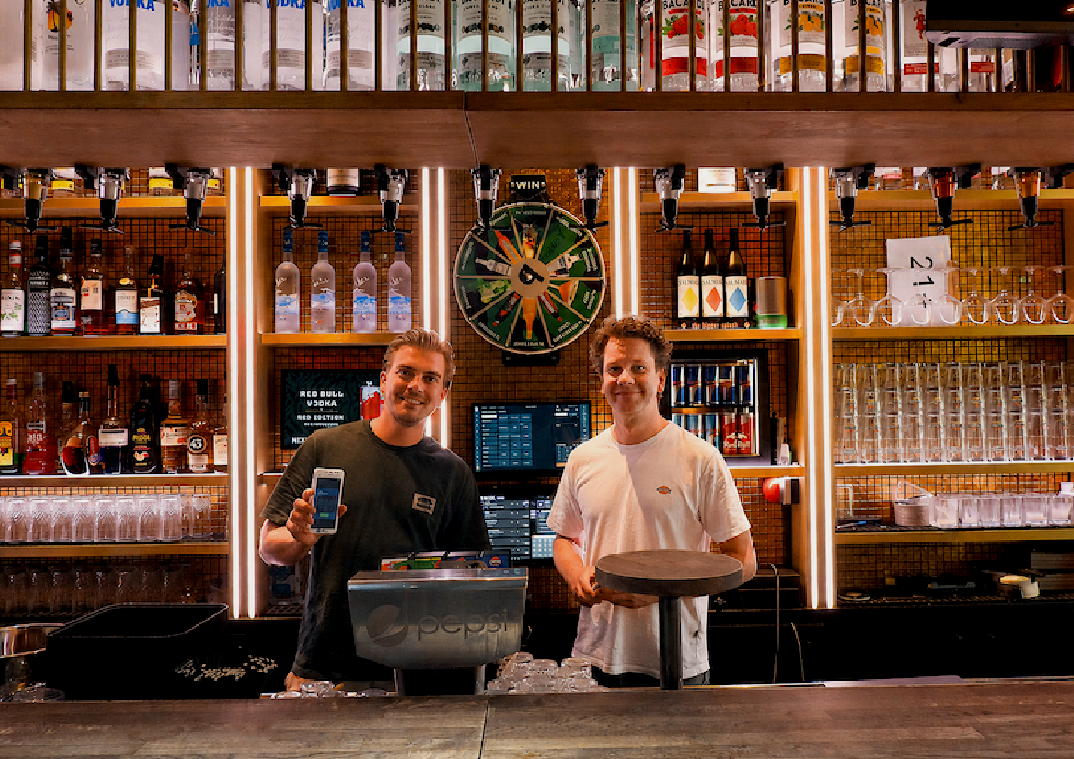 Ondernemer en adviseur achter de bar met handheld